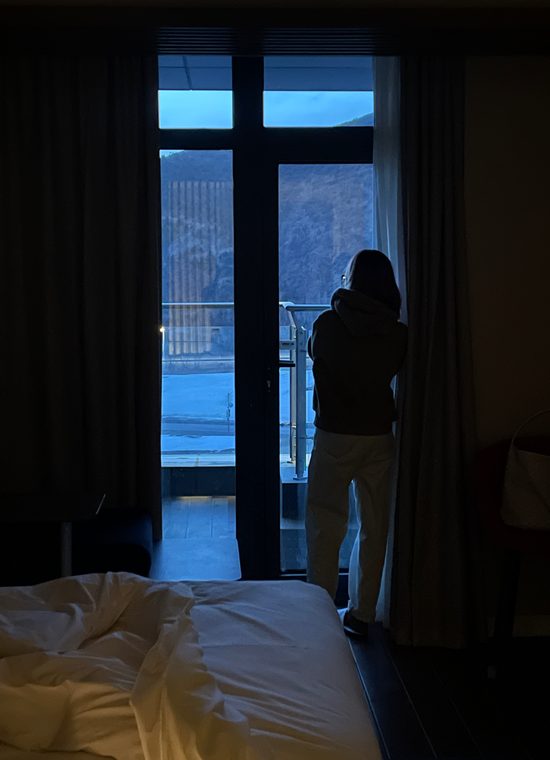 Courtside 24 / Dark hotel room with window light