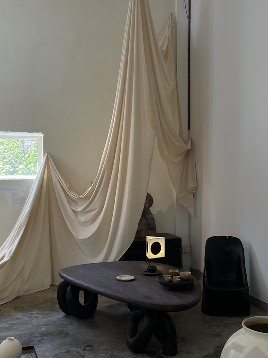 Foreign Body 19 / Draped cloth and small table in a room